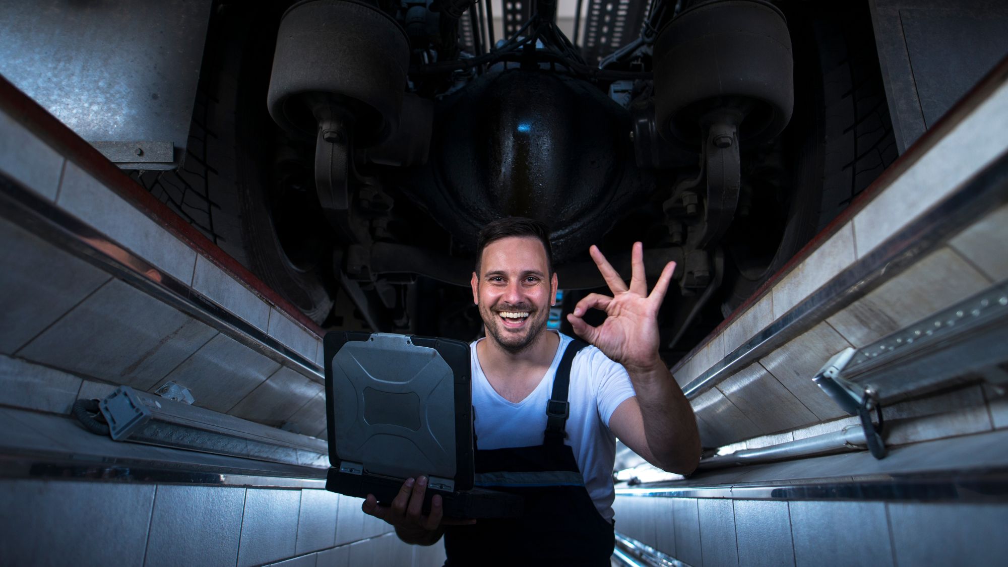 A mechanic in a happy mood after successful car upgrades of his customer