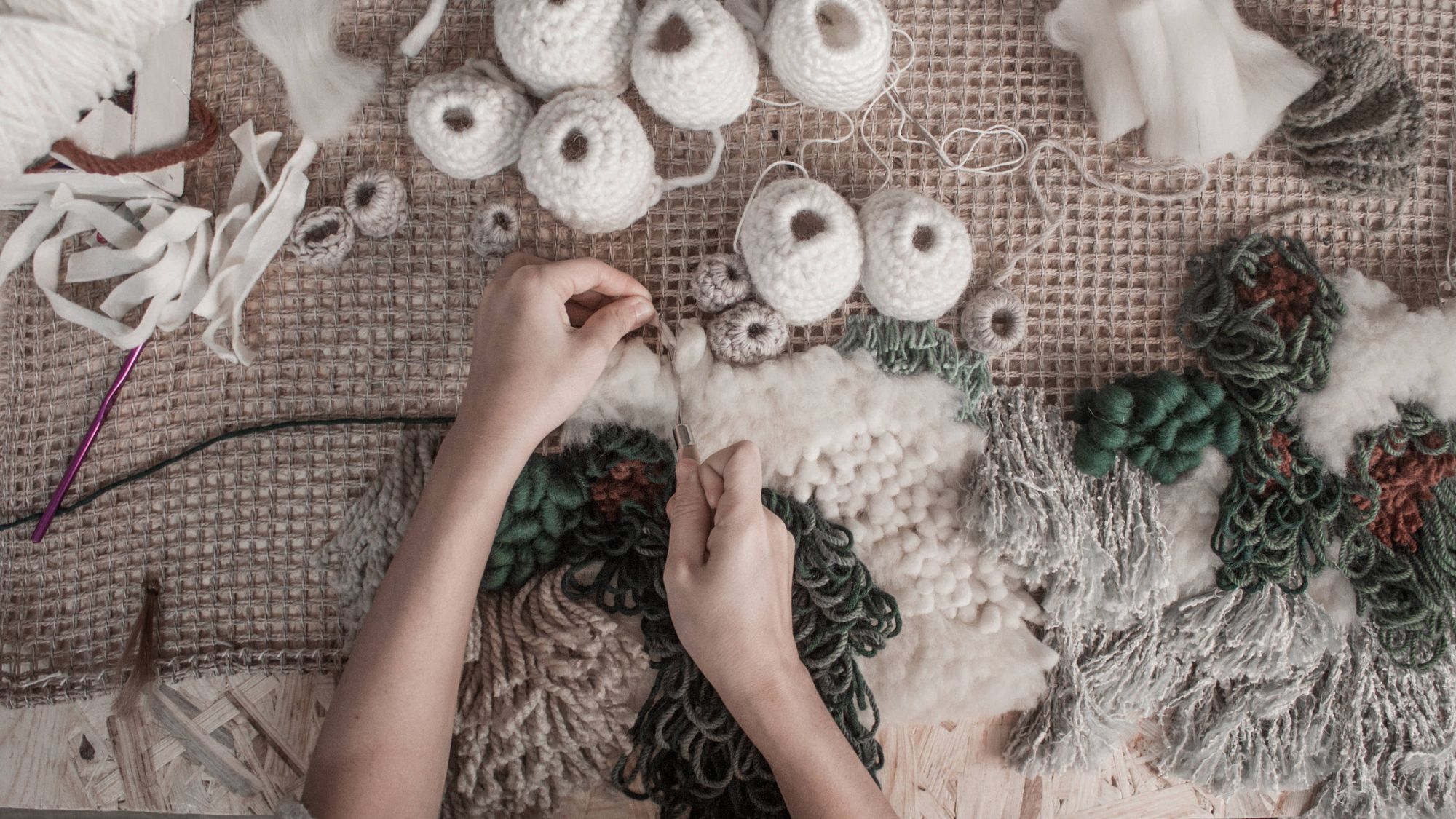 A woman doing embroidery on a cloth with the techniques used in textile art